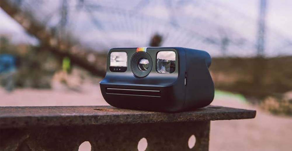 Polaroid Go Gen 2 en color negra montada en una viga de hierro vista de perfil