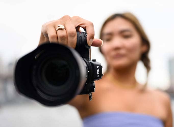 Chica sosteniendo la Nikon Z6 II Cámara Digital sin espejo vista frontal