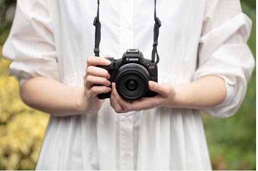 Chica tomando una fotografía con la Canon EOS R50 Cámara mirrorless con objetivo 18-45 mm
