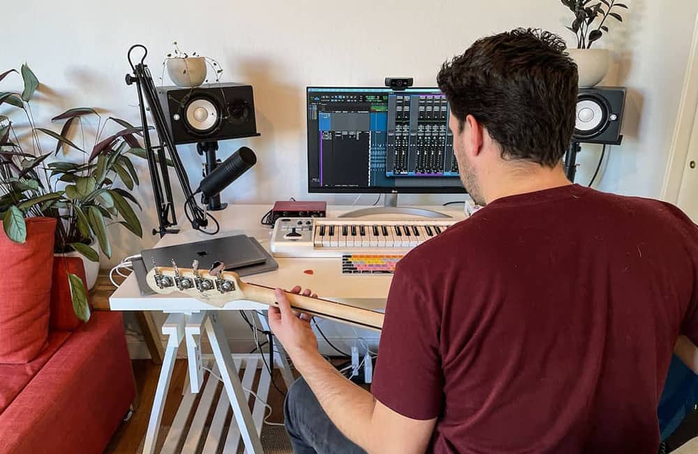 Hombre tocando guitarra y usando Pro Tool Studio
