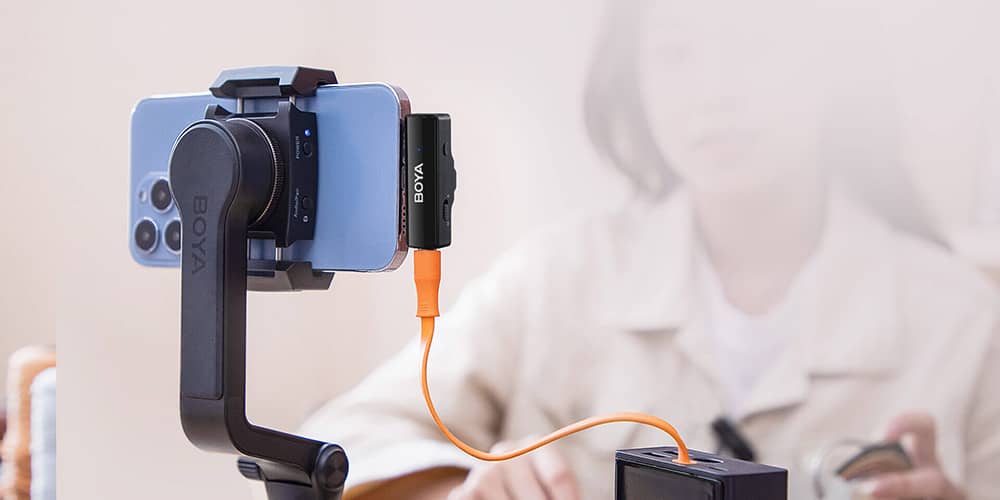 BOYA BOYALINK receptor conectado a un celular y cargandose con una batería externa