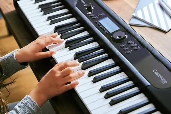 Mujer tocando el teclado portátil Casio CT-S400