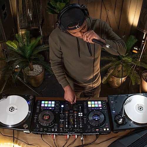 DJ manejando el Pioneer DJ DDJ-800 conectado a dos tornamesas vista superior