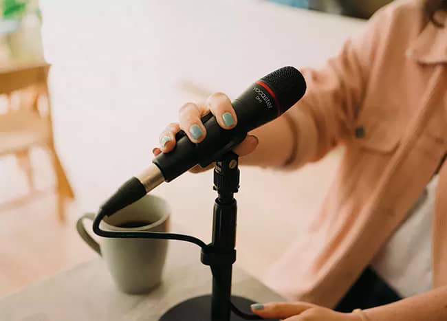 Mujer usando el micrófono DM1 del Kit Vocaster One Studio