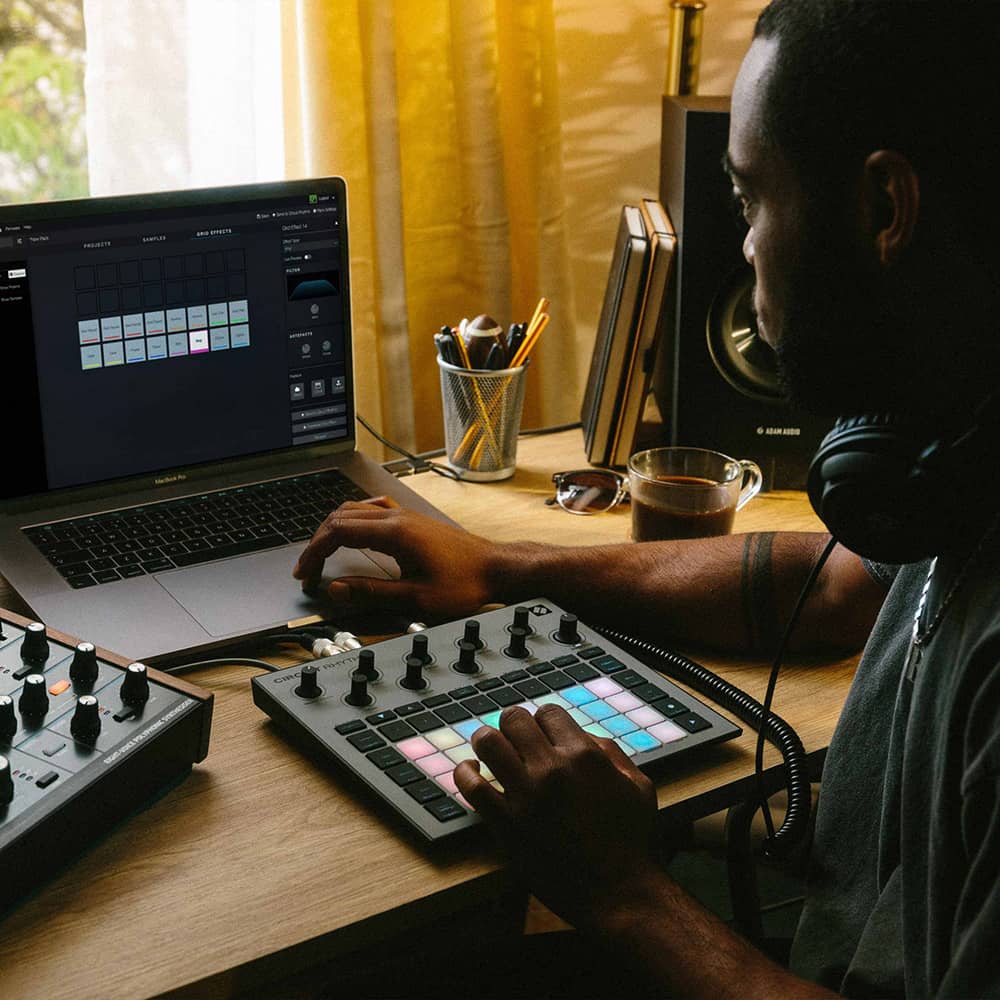 Músico creando pistas con el Novation Circuit Rhythm y una laptop