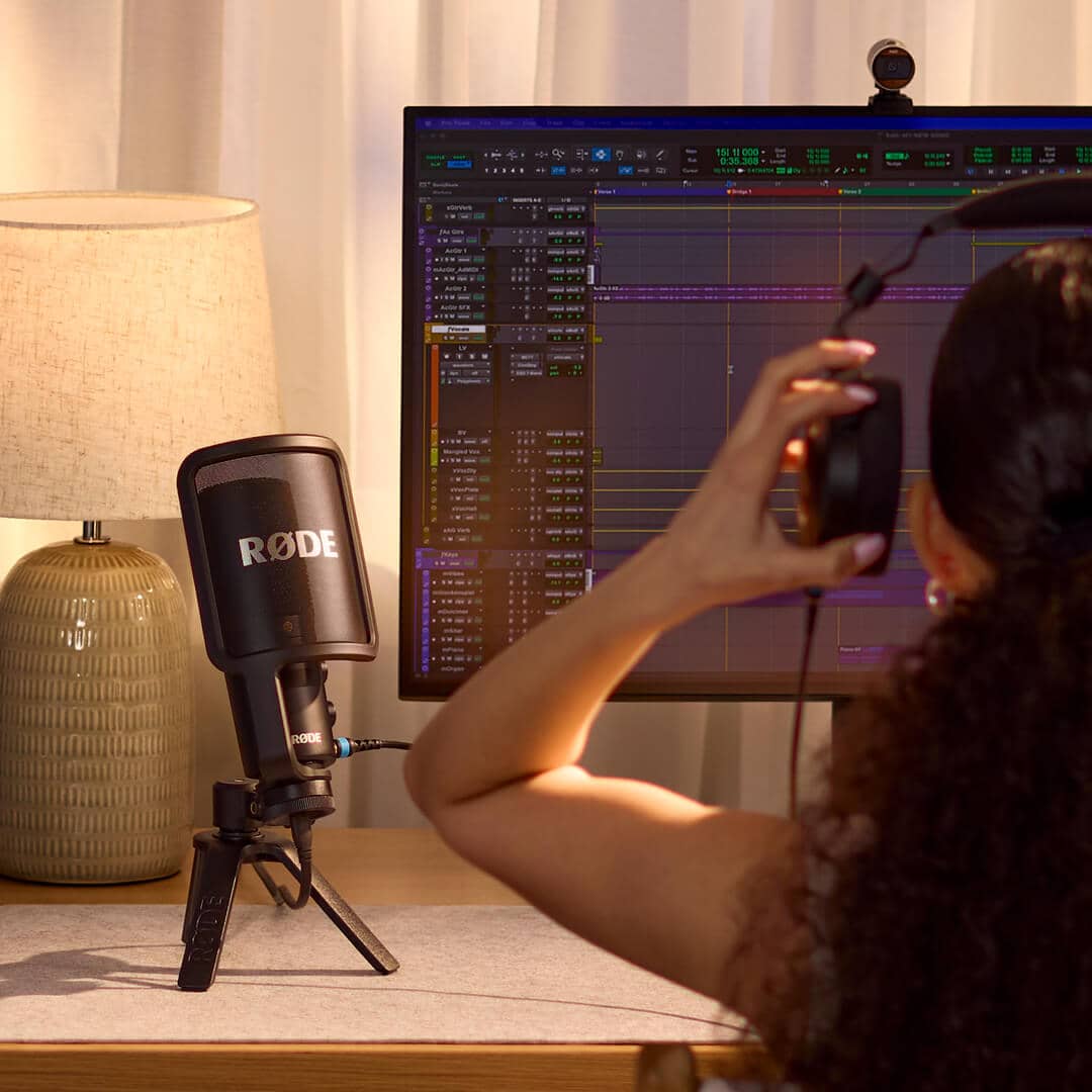 Mujer usando unos audifonos conectado al Micrófono RODE NT USB+