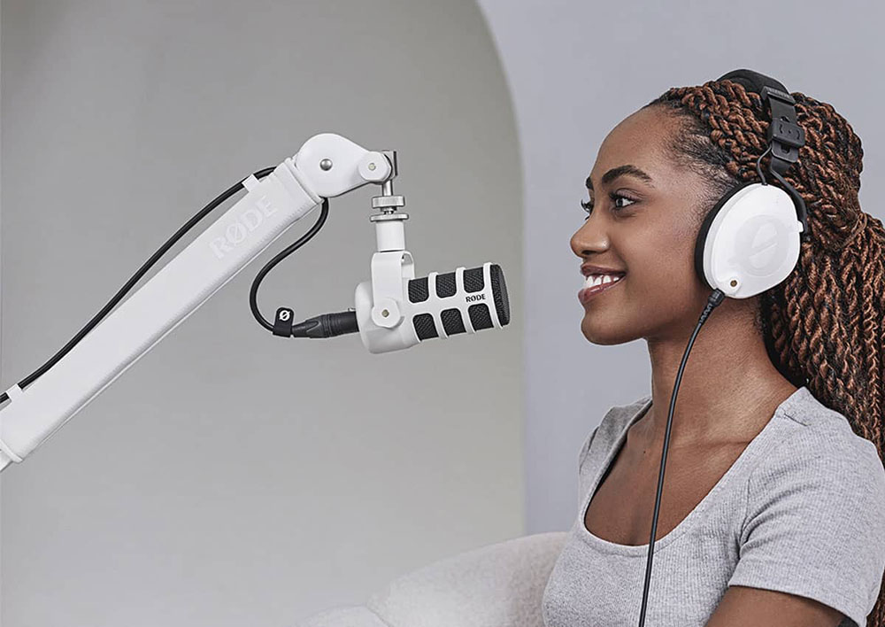 Chica usando el Micrófono Dinámico para Podcast RODE PodMic (Blanco) montado en brazo para micrófonos Chica usando el Micrófono Dinámico para Podcast RODE PodMic (Blanco) montado en brazo para micrófonos